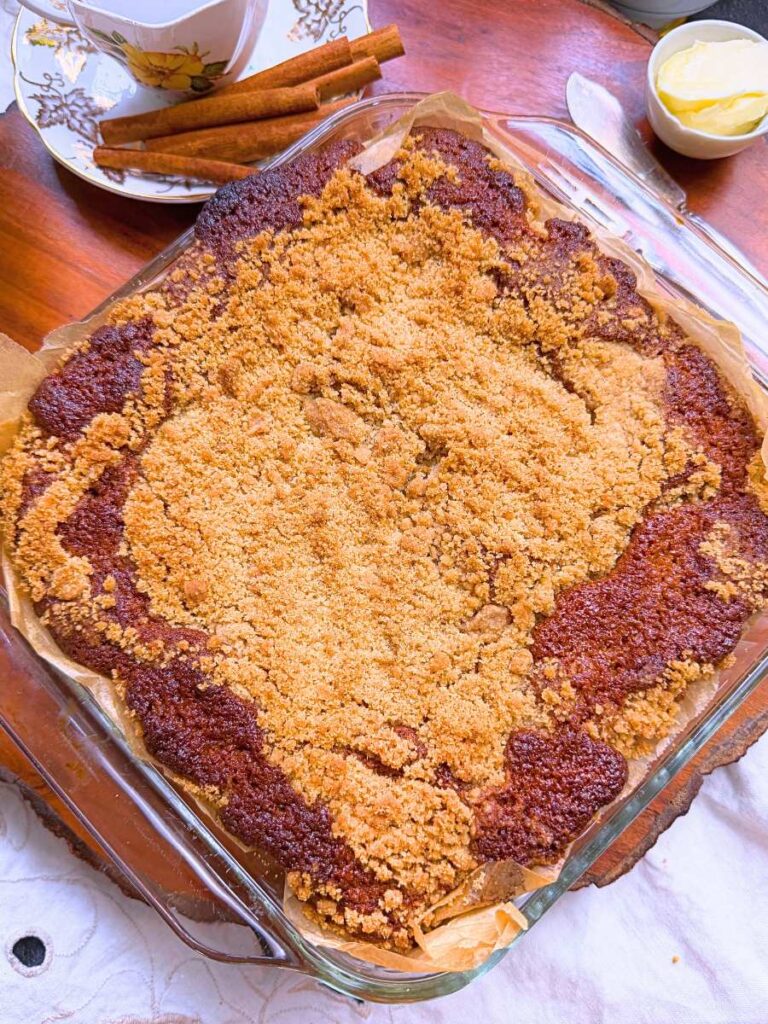 A baked coffee cake with a streusel topping in a glass baking dish.