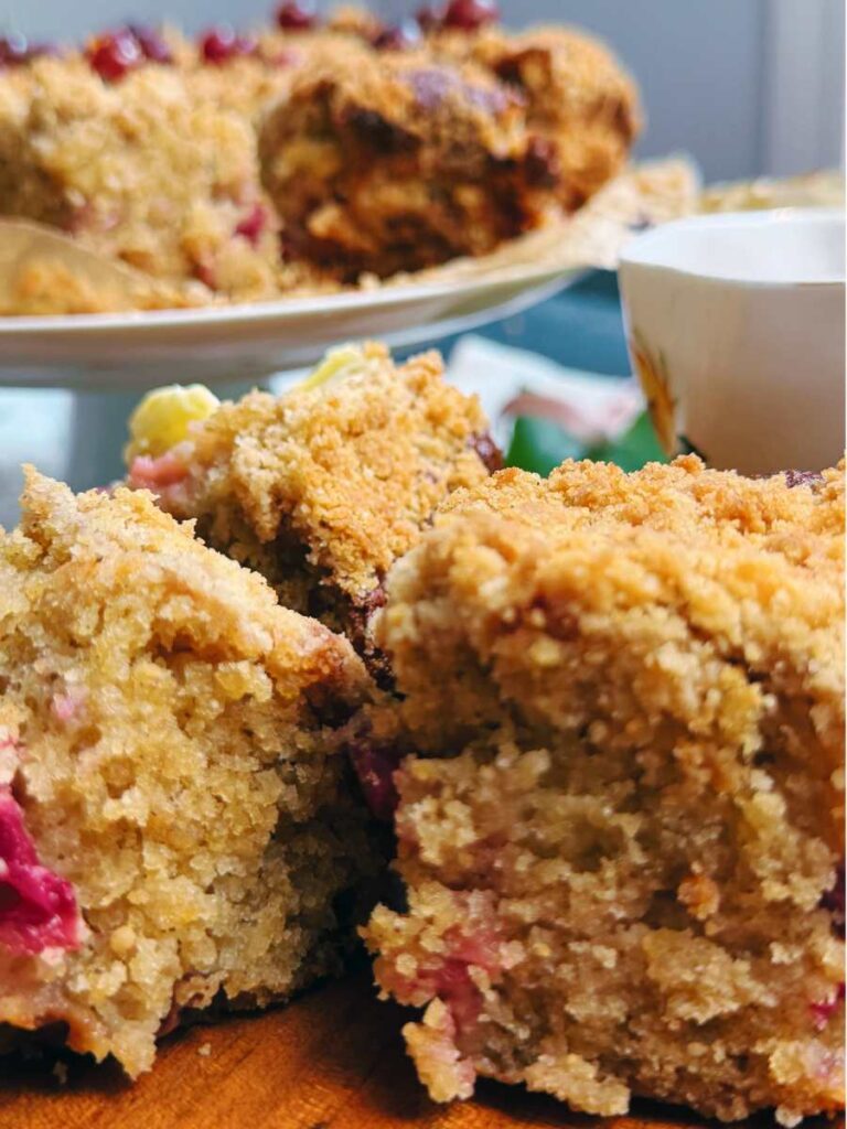 Some slices of gooseberry coffeecake. There is more on a cake stand behind.