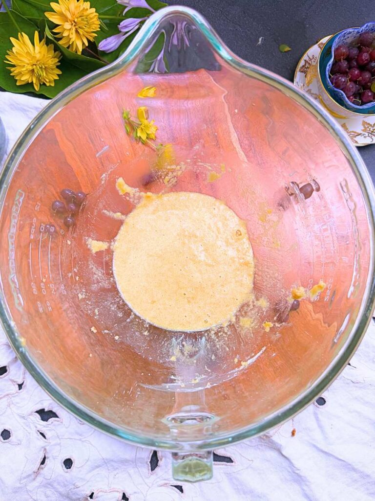 A large glass bowl with butter, sugar, and an egg creamed together.
