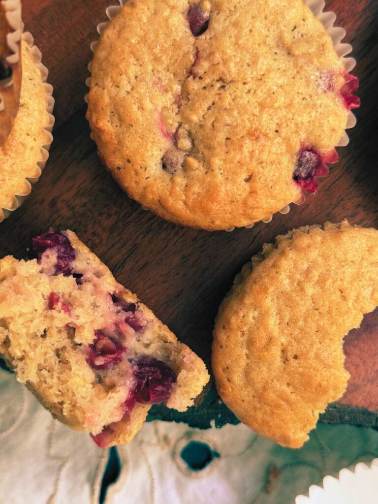 A close up look at two gooseberry muffins. One is slit in half.
