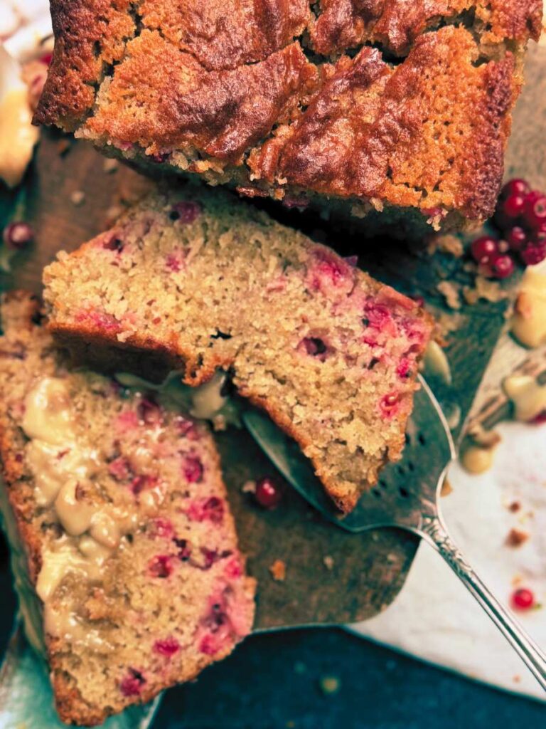 An overhead view of a sliced red current loaf cake.