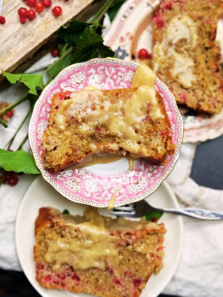 Three slices of red current loaf cake on plates.