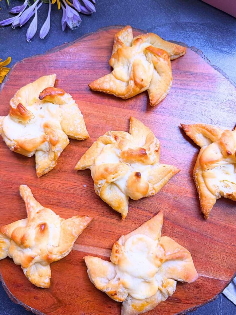 Baked cheese danishes on a wooden board.