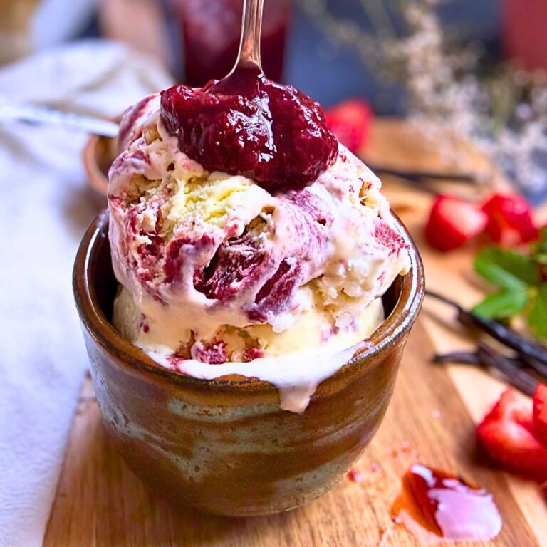 A brown bowl filled with strawberry and vanilla ice cream. There is a spoonful of strawberry sauce on top.