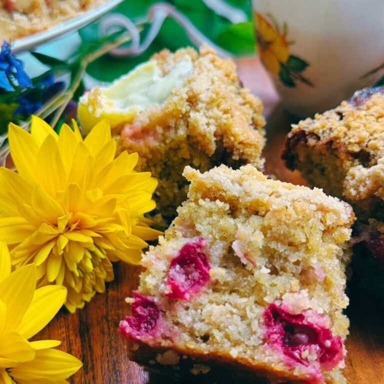 Three slices of gooseberry coffee cake with a yellow flower beside.