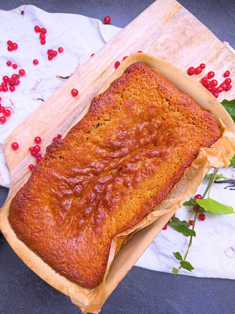 A baked red current loaf cake in a stone loaf pan.