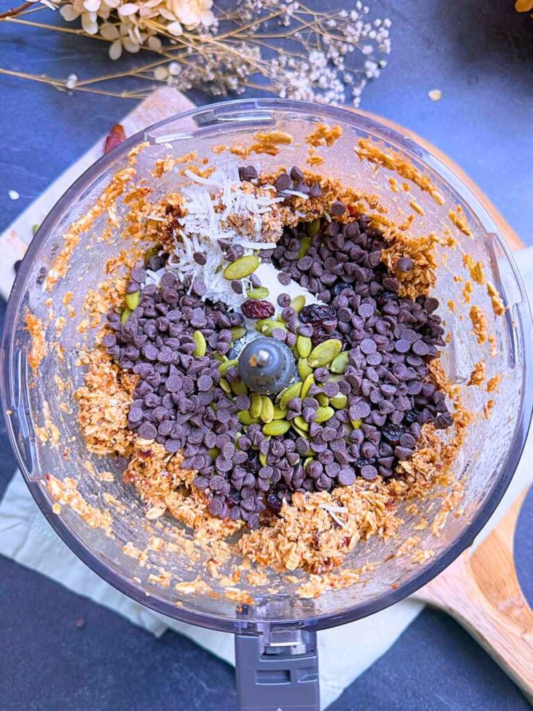 Mini chocolate chips, pumpkin seeds, Craisins, and shredded coconut on top of an oat mixture.