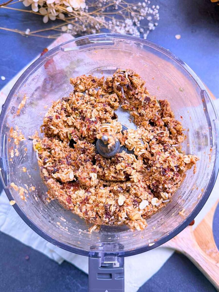 A granola bar mixture in a bowl of a food processor.