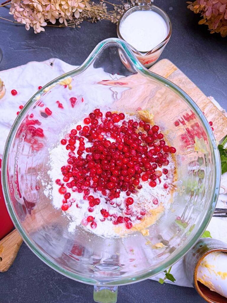 Dry ingredients with fresh red currents on top. It is in a large glass bowl.