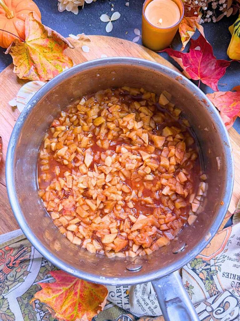 An apple and cinnamon filling in a metal sauce pot.