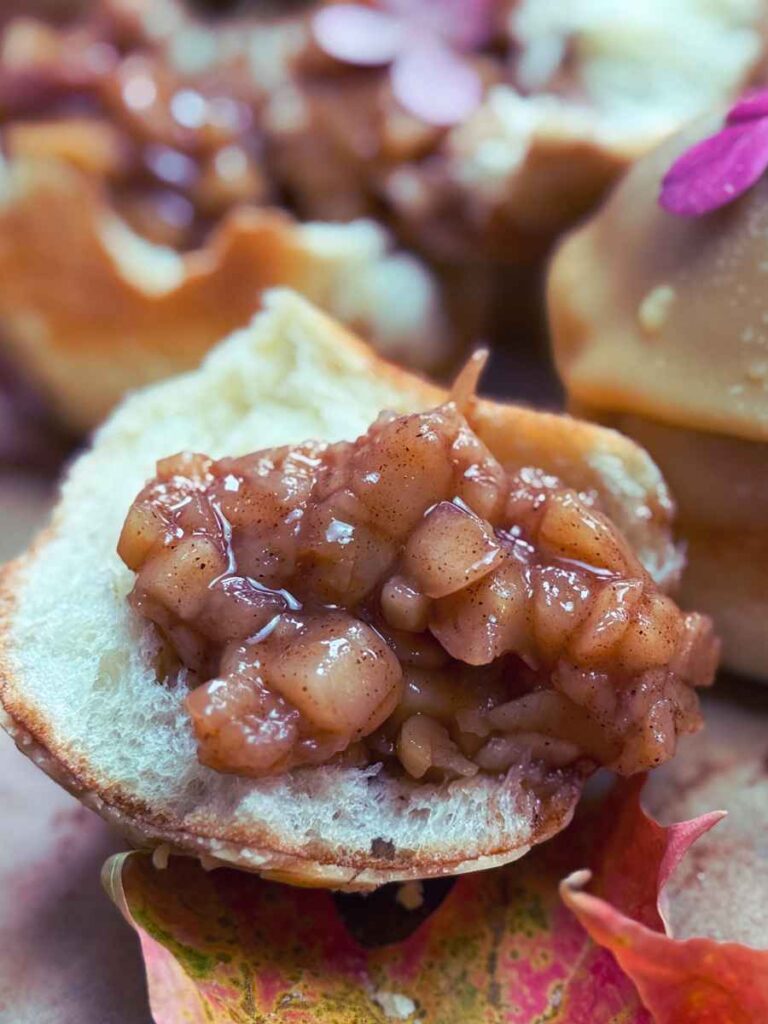 A close up look at the inside of an apple cinnamon stuffed brioche doughnut.