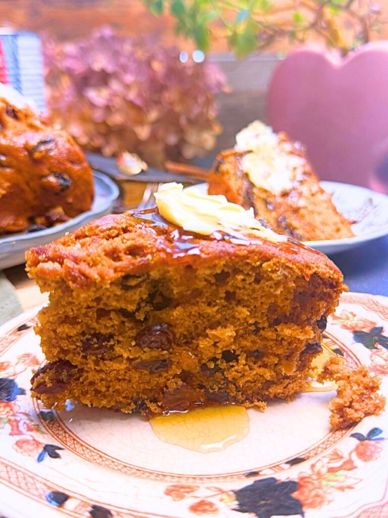 A side view of a slice of Canadian war cake with a little butter and syrup on top.