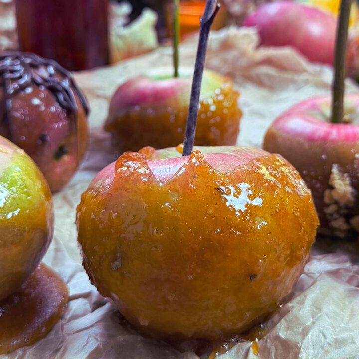 A close up look at a maple dipped candy apple. There are more in the background.