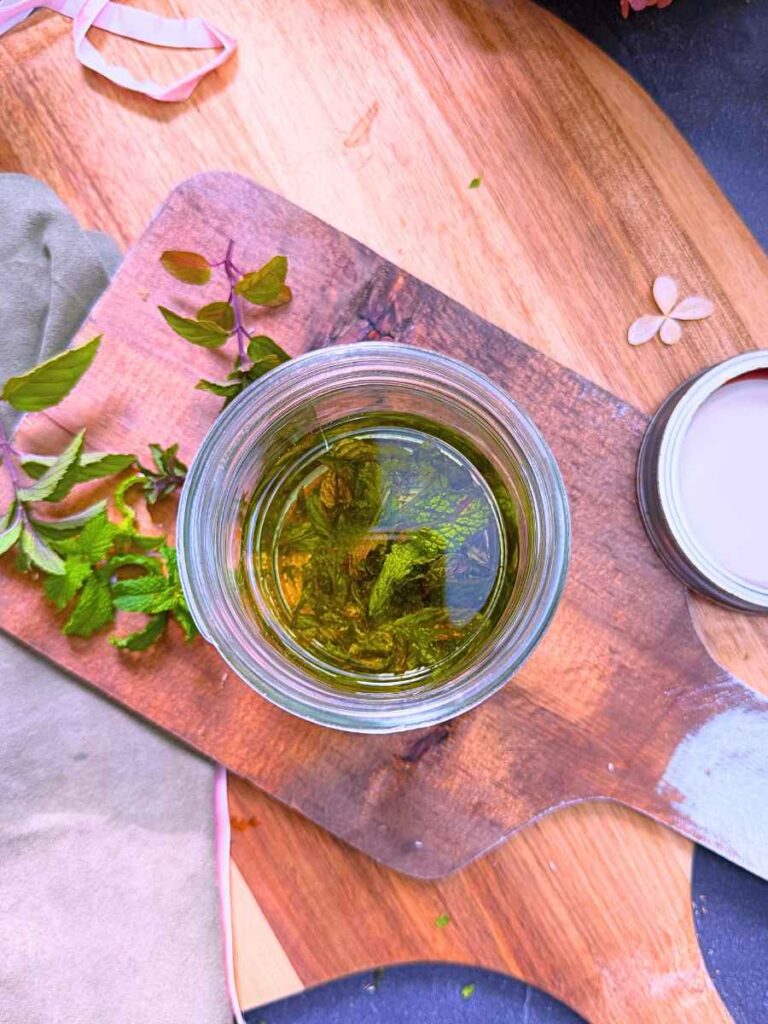 Vodka and mint leaves in a glass canning jar.