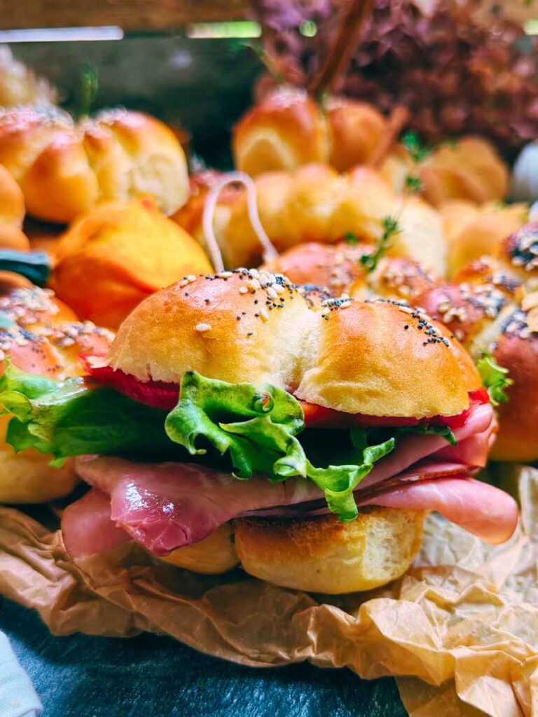 A side view of a sandwich made out of a pumpkin shaped bread roll.