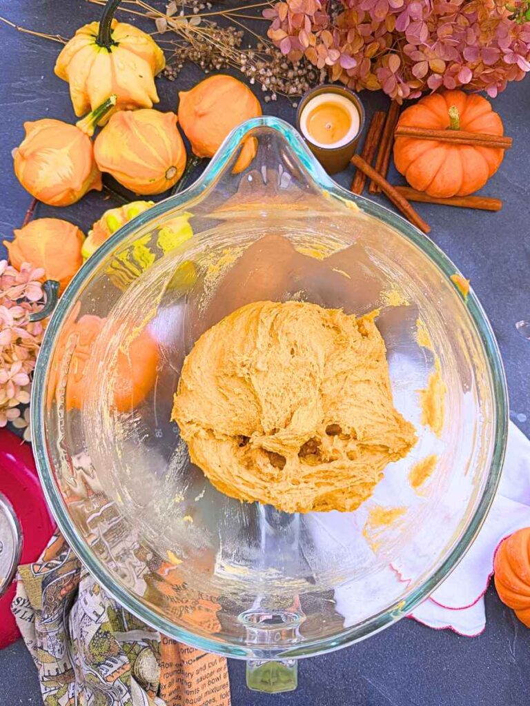 Baked pumpkin doughnut dough in a large glass bowl.