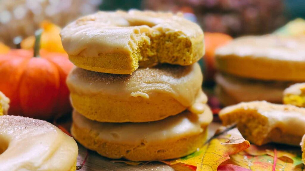 Three stacked pumpkin doughnuts with a caramel icing.