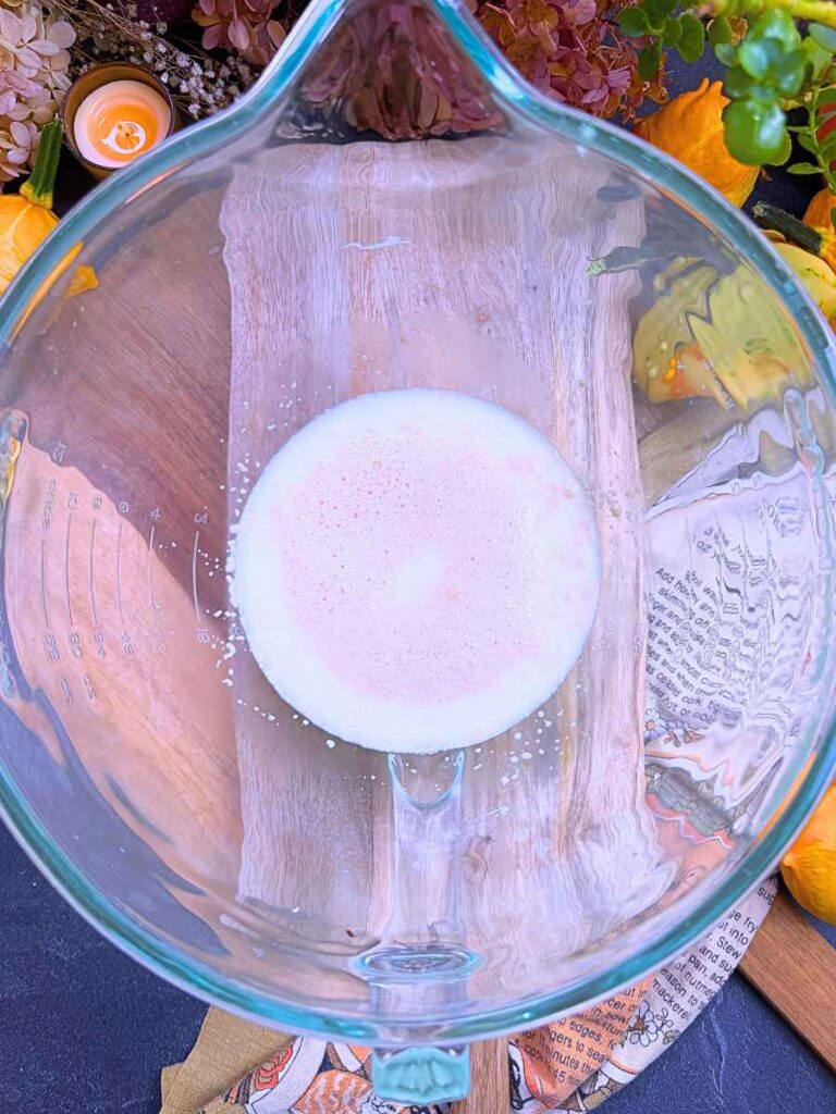 A large glass bowl with milk and yeast inside.