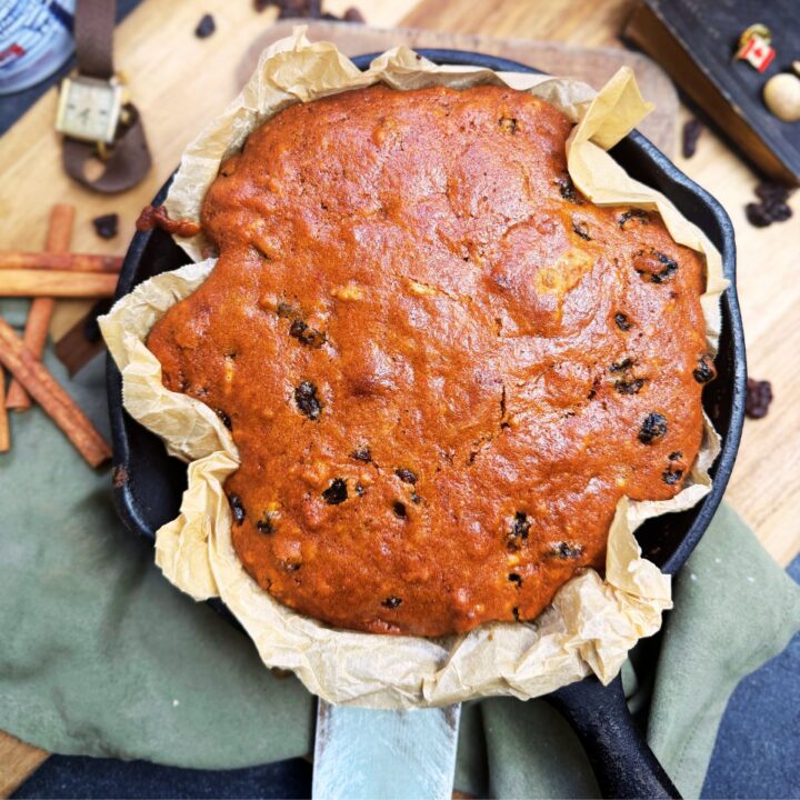 A baked Canadian war cake in a parchment lined cast iron skillet.