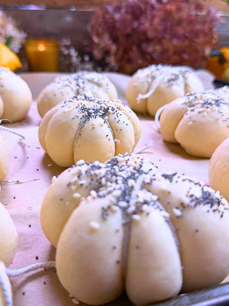 Risen dinner rolls shaped into pumpkins with kitchen twine.