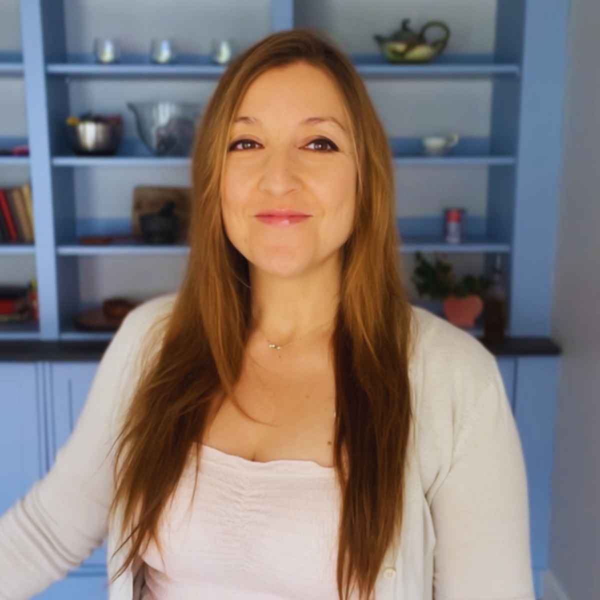 A woman standing in front of blue shelves.