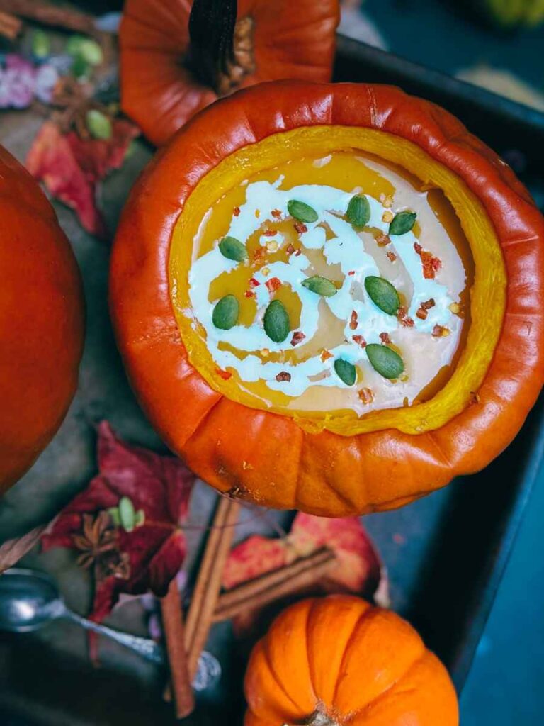 A cooked pumpkin with pumpkin soup inside.