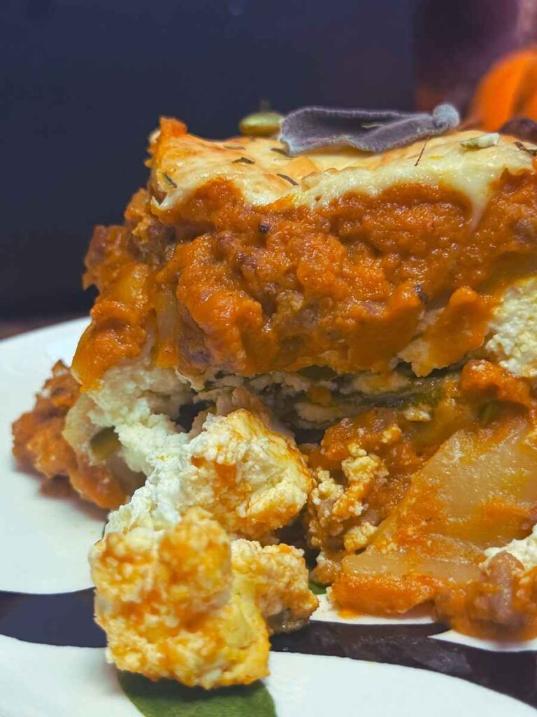 A side view of a slice of pumpkin lasagna on a white plate.