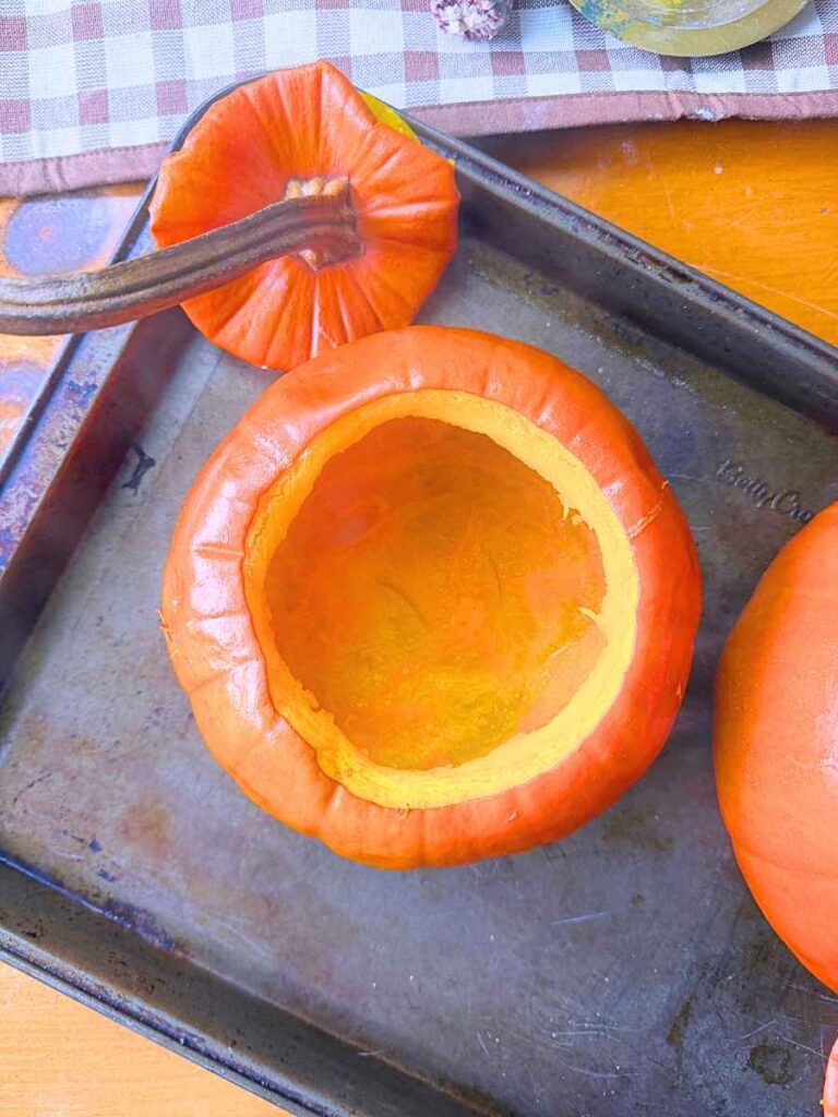 A cooked pumpkin on a baking sheet.