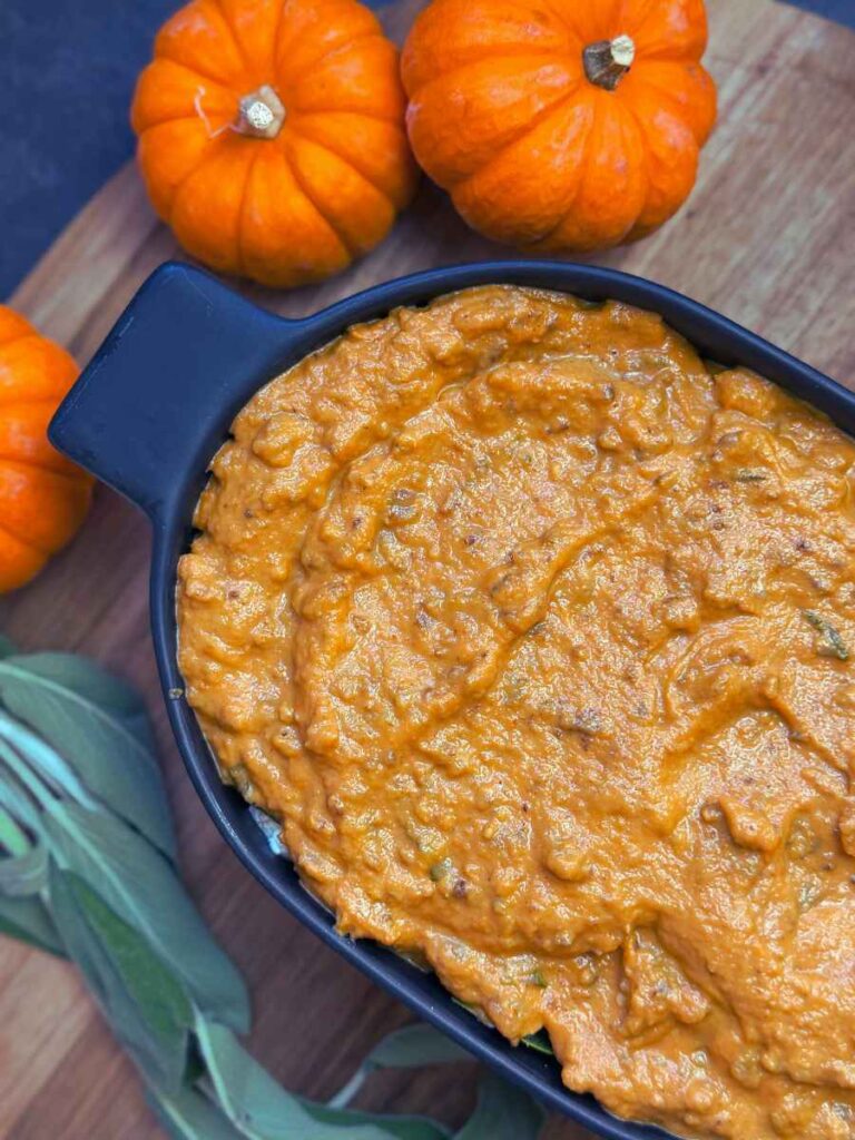 A pumpkin sauce lasagna in a black casserole dish.