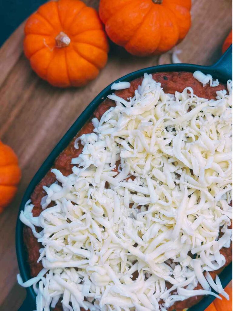 Pumpkin lasagna topped with grated cheese.