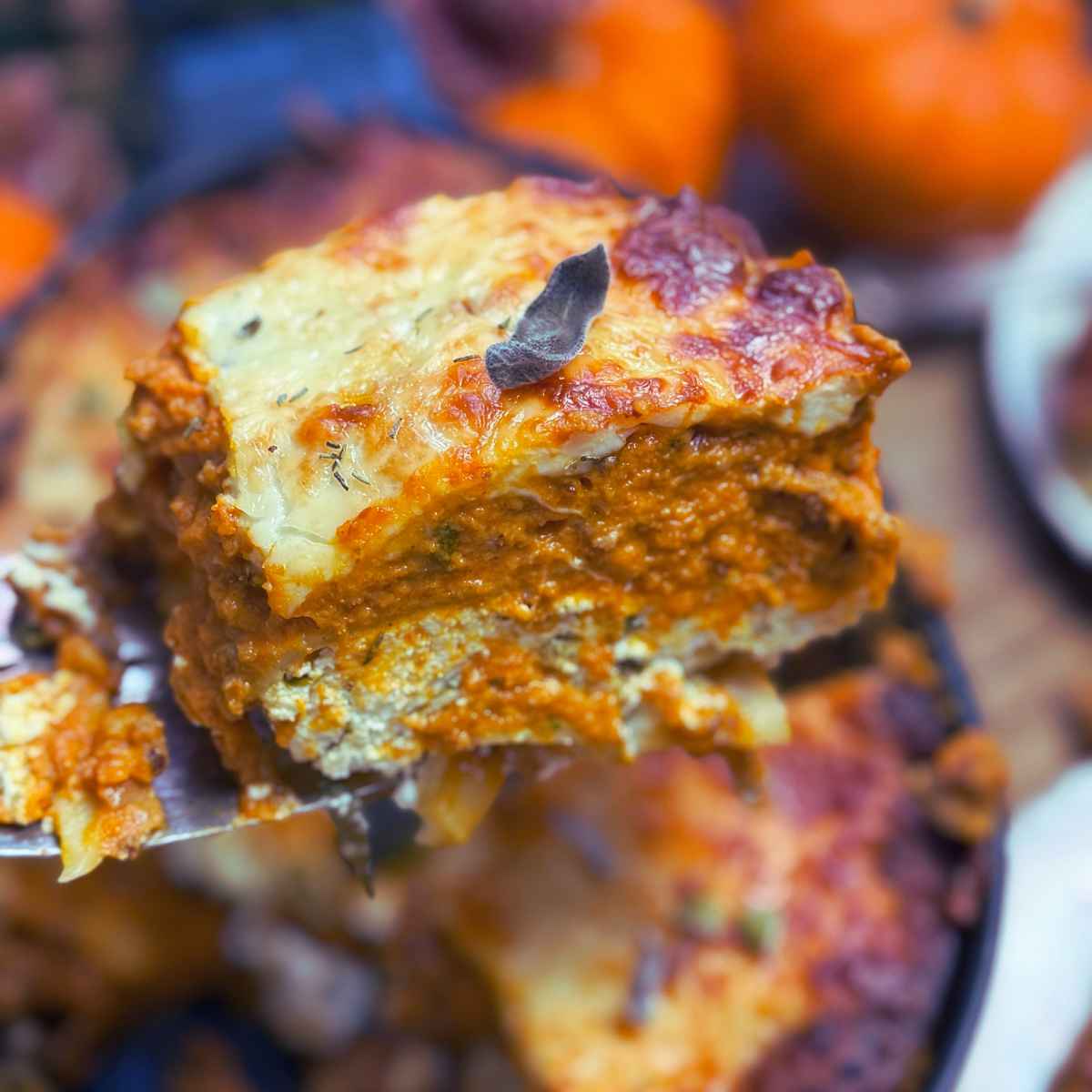 A woman is holding a serving of pumpkin lasagna.